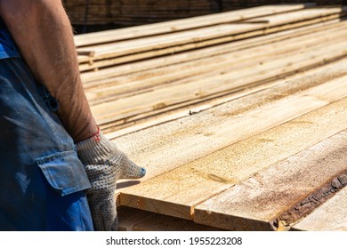 Industrial Warehouse Of A Sawmill, An Employee Puts His Hands On The Finished Products At The Sawmill In The Open Air. Commercial Background Of The Hand On The Left Side.