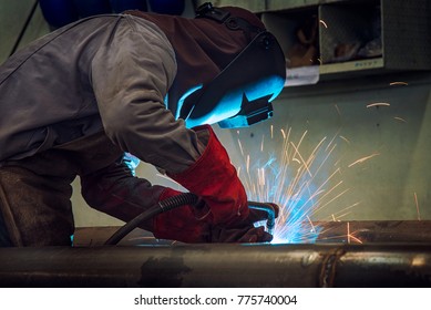 Industrial welder welding fabricated construction in factory Welding process by Shielded Metal Arc Welding (SMAW) or Stick Welding.