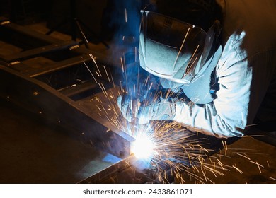 Industrial Welder at Work with Sparks Flying in Workshop - Powered by Shutterstock