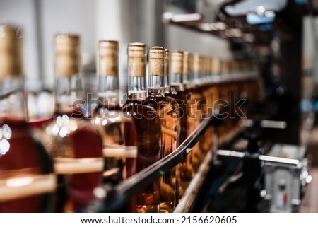 Industrial wine bottling plant theme. Modern industry production line for alcohol drink bottling and packaging. 
