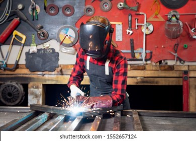 Industrial work, welder works with metal, sparks and fire on background of workplace. - Powered by Shutterstock