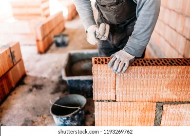 Industrial Worker, Bricklayer And Mason Working With Bricks And Building Interior Walls Of House