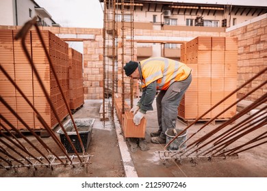 Industrial Worker, Bricklayer And Mason Working With Bricks And Building Interior Walls Of House