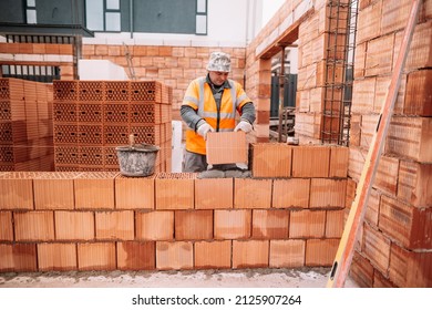 Industrial Worker, Bricklayer, Mason Working With Bricks And Building House