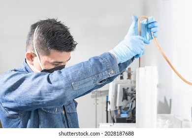 Industrial Worker With Face Protection Mask And Blue Latex Gloves Performs Tests In The Geology Or Scientific Lab