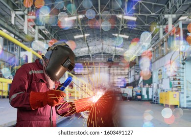 Industrial Worker At The Factory Welder Is Welding Process Close Up With Protective Equipment Mask, PPE Marks Welder With Bokeh Background.