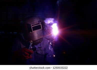 Industrial Worker At The Factory Welding Close Up In Side Confined Tank, A Large Cargo Ship Repair In Dry Dock On Dark Tone