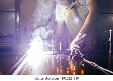 Industrial Worker At Factory Welding Closure