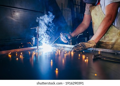 Industrial worker at factory welding closure