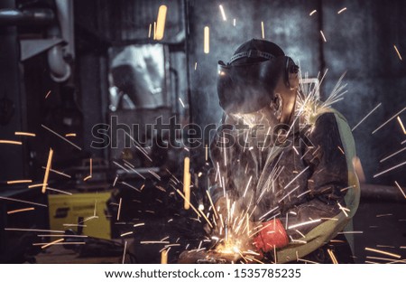 Industrial Worker laborer at the factory welding steel structure