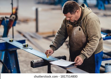 Industrial worker looking at blueprint - Powered by Shutterstock