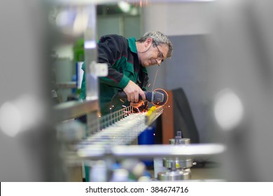 Industrial Worker In Manufacturing Plant Grinding Steel Structure. Sparks From Grinding Machine In Workshop. Industrial Background, Industry.