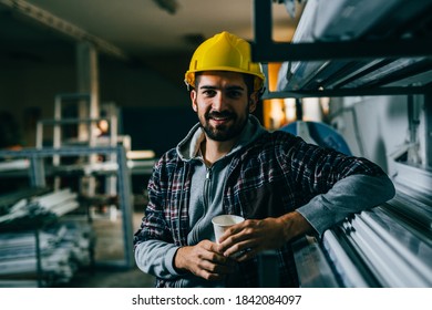 industrial worker on lunch break, holding cup of coffee and looking at camera - Powered by Shutterstock