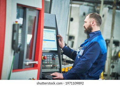 Industrial worker operating cnc machine at metal machining industry - Shutterstock ID 1971109892