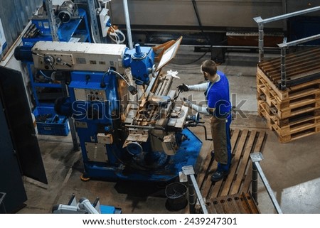 Industrial worker operating drilling machine.
