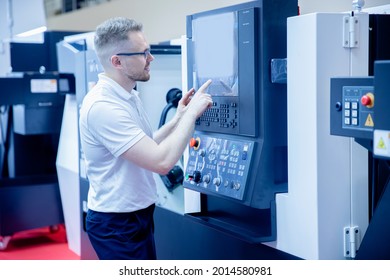 Industrial Worker Operator Use Automated Control Panel CNC Turning Machine At Automatic Modern Factory Floor. Concept Engineer Industry Metal Workshop.