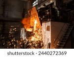 Industrial worker oversees molten metal pouring from furnace at steel mill. Foundry specialist in protective gear supervises smelting process. Heavy industry, high temp steel production.