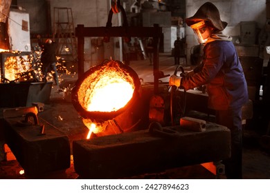 Industrial worker pours molten metal at foundry. Steel production in heat-resistant suit, helmet. Heavy industry labor. Metallurgy process, smelting iron in blast furnace. Metalwork, hot iron casting. - Powered by Shutterstock