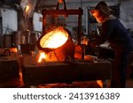 Industrial worker in protective gear pours molten metal at steel foundry. Manufacturing process in heavy industry with furnace. Skilled laborer handles high-temperature metallurgy, safety action.