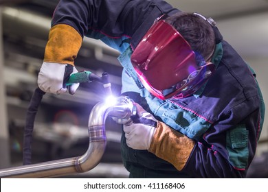 Industrial Worker With Protective Mask Welding Inox Elements In Steel Structures Manufacture Workshop.