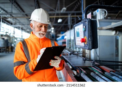 Industrial Worker In Safety Visible Uniform And Hardhat Inspecting Process Of Production And Machine Operations In Factory.