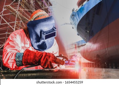 Industrial Worker Shipbuilding Industry At The Factory Welding Close Up On Ship Moored In Floating Dry Dock In Shipyard. And Scaffolding Background.