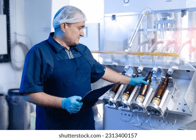 Industrial worker use control panel on production line with glass bottles beer in brewery. Concept modern automatic food drink industry. - Powered by Shutterstock