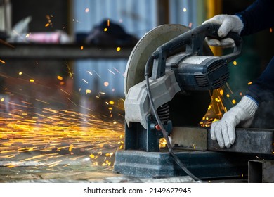 Industrial worker using electric grinder cutting metal, Electric grinder cutting metal bright sparks, Metal grinder cut iron pipe cutting metalwork manufacturing and construction maintenance service.