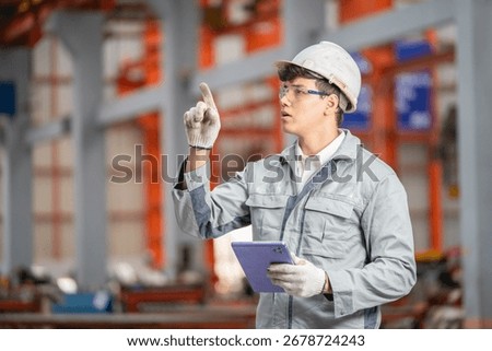 Industrial worker using tablet to direct operations in factory setting professional environment focused viewpoint digital communication