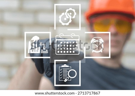 Industrial worker using virtual touch screen presses the icon CALENDAR. Industry planning, production scheduling, time management, organization concept. Organizing manufacturing work tasks.