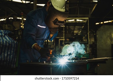 Industrial worker welding metal with many sharp sparks - Shutterstock ID 1710597214