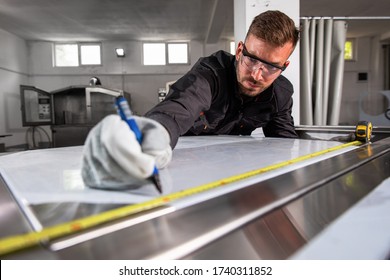 Industrial worker working on metal structure making marks with measuring meter at workshop. - Shutterstock ID 1740311852