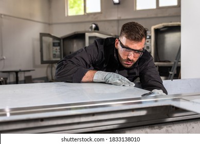 Industriearbeiter, der an Metallkonstruktionsmarken arbeitet, die Messgeräte in der Werkstatt enthalten.