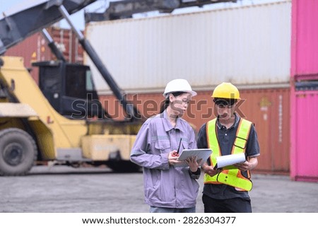 Industrial workers checking shipment documents and digital logistics data at shipping yard.