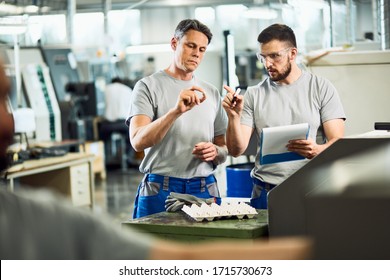 Industrial Workers Cooperating While Doing Quality Control Of Manufactured Products In A Factory. 