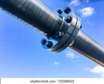 Industrial zone, Steel pipelines , valves and flange against blue sky