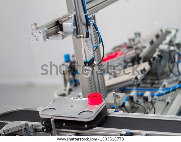 Industry 4.0\
concept; artificial intelligence in manufacturing. Gripper picks up\
the product from automated car which is on the manufacturing line\
in a smart factory. 