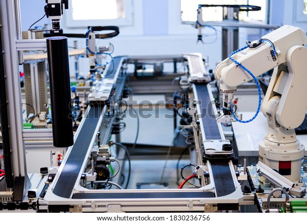 Industry 4.0 concept; artificial intelligence in smart\
factory prototype. Close- up the robot picks up the product from an\
automated car on the production line. Focus on the robotic arm\'s\
gripper. 