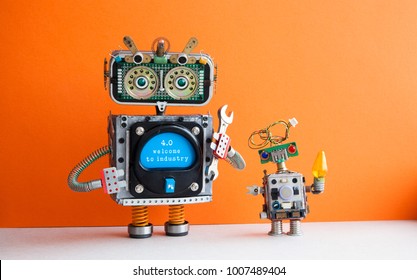 Industry 4.0 concept. Big IT specialist robot with hand wrench and small robotic cyborg. Welcome to the new economic future message on blue display. Orange wall background.