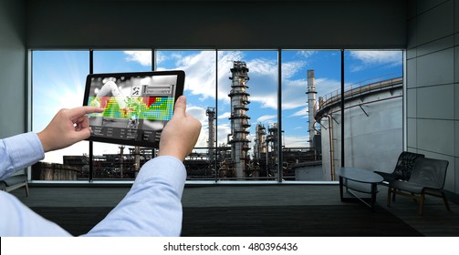 Industry 4.0 Concept .Man Hand Holding Tablet With Augmented Reality Screen And Automate Wireless Robot Arm Software At Industrial Room In Smart Factory.Window Showing Oil Refinery Industry Background