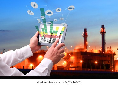 Industry 4.0 Concept .Man Hand Holding Tablet With Augmented Reality Screen And Automate Wireless Robot Arm Software At Industrial Room In Smart Factory.Window Showing Oil Refinery Industry Background