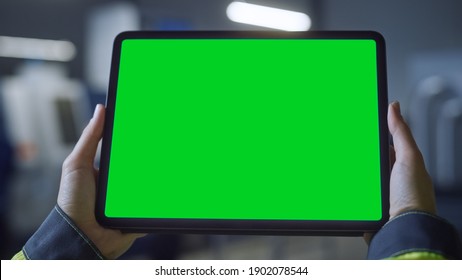 Industry 4.0 Factory: Chief Engineer and Project Supervisor Holds Digital Tablet Computer with Green Screen, Chroma Key. Workshop with Machinery. - Shutterstock ID 1902078544