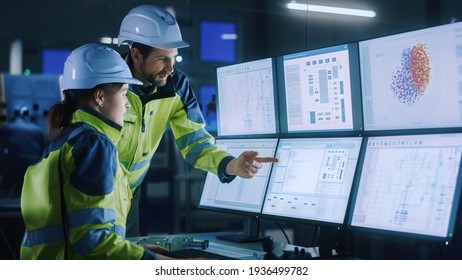 Industry 4.0 Modern Factory: Chief Project Manager Talks to Female Engineer, She Points at Computer Screens Showing Complex Industrial Electronics Design Blueprints, They Have Find Problem Solution - Shutterstock ID 1936499782