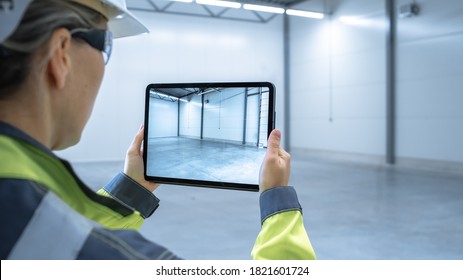 Industry 4.0 Modern Factory: Female Engineer Uses Digital Tablet Computer with Augmented Reality Software Visualizing of Manufacturing Plant Room Mapping, Factory Layout. Concept Shot Suitable for AR.