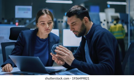 Industry 4.0 Modern Factory Meeting Room: Chief Engineer Holds Mechanism, Shows It To Female Designer, They Talk. Scientists In Contemporary Lab Build Electronic Machinery For With Futuristic Design