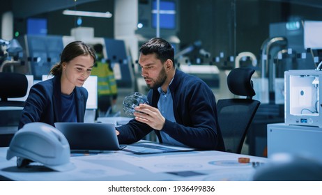 Industry 4.0 Modern Factory Meeting Room: Chief Engineer Holds Mechanism, Shows It To Female Designer, They Talk, Use Laptop. Scientists In Lab Build Electronic Machinery For With Futuristic Design