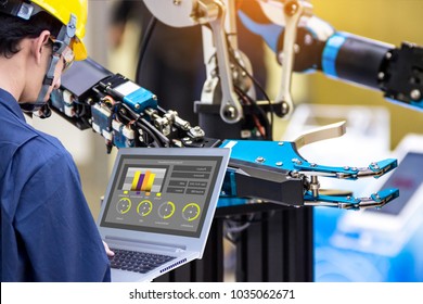 Industry 4.0 Robot Concept .Engineers Use Laptop Computers For Machine Maintenance, Automation Tools, Robot Arm At The Factory.
