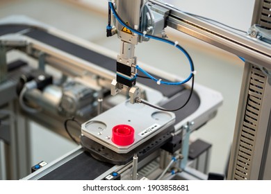 Industry 4.0 smart factory concept; artificial intelligence in production. Gripper picks up the product from automated car. Selective focus. - Shutterstock ID 1903858681