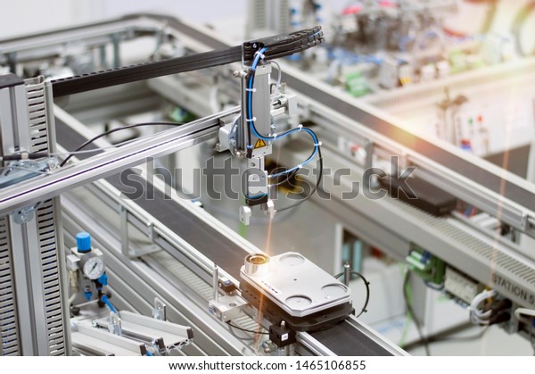 Industry 4.0 smart factory concept; artificial\
intelligence in production. Gripper picks up the product from\
automated car. Selective\
focus.