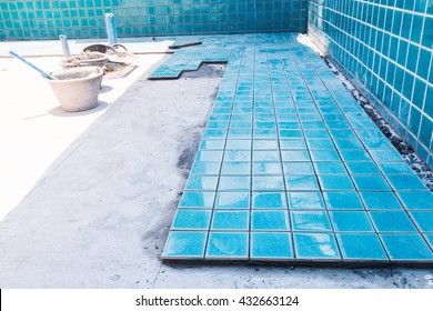 Industry building construction architecture worker professional man builder are installation blue swimming pool ceramic tiles on cement concrete floors and wall